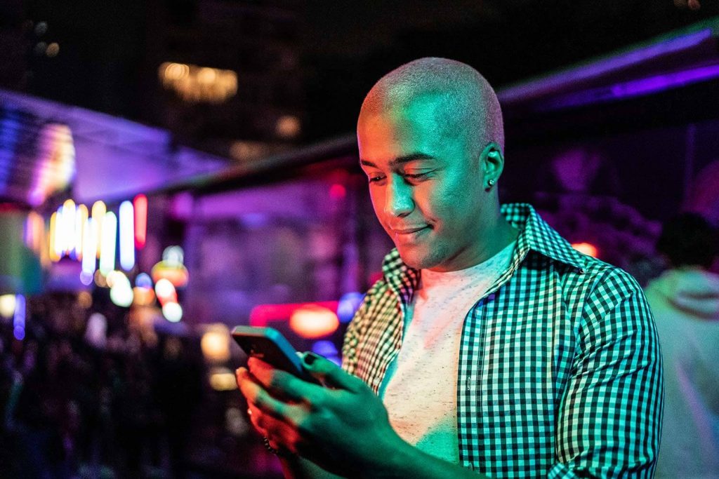 club goer on his phone checking listings