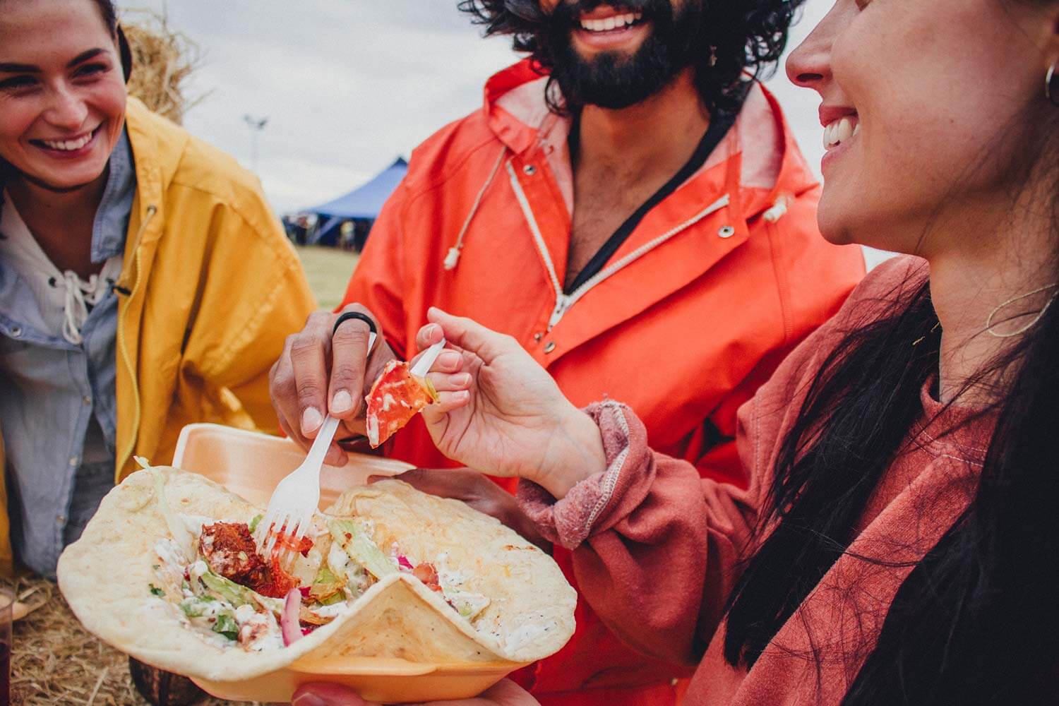 group of friends sharing food at a food festival group of friends sharing food at a food festival