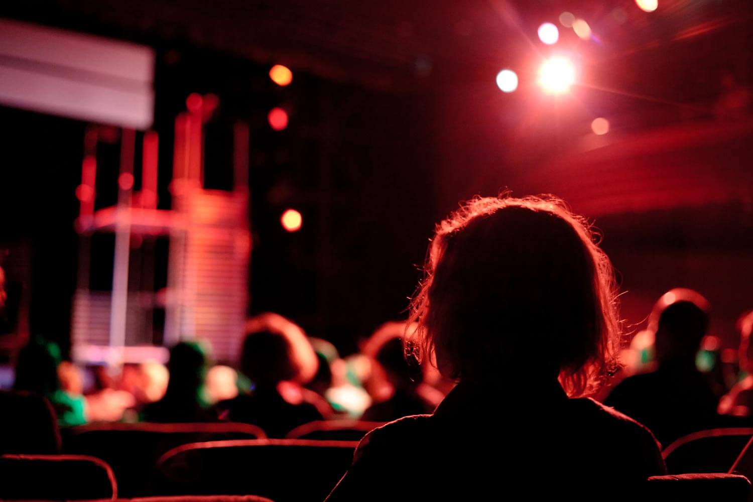 woman in theatre audience waiting for the show to start woman in theatre audience waiting for the show to start
